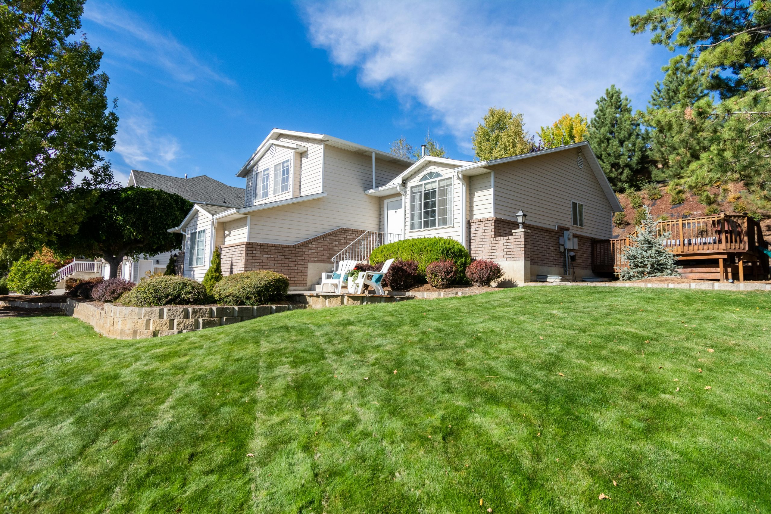 two-story house with a bright green, well-manicured lawn